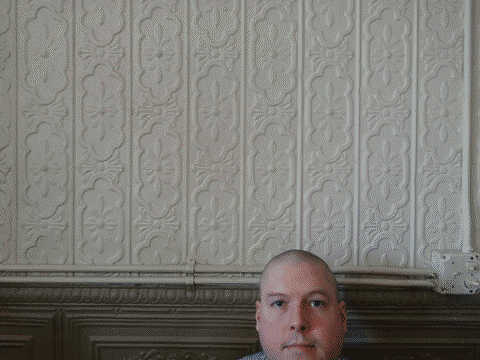 A photo of me standing in front of a painted tin wall